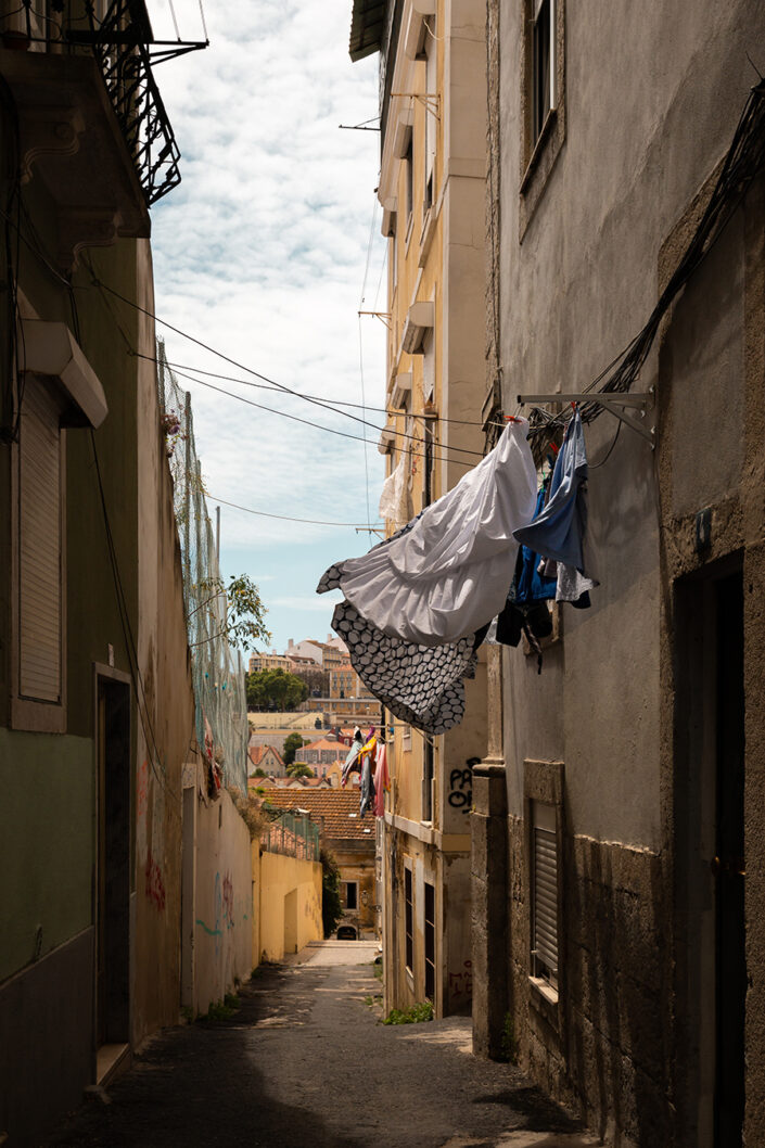 Eine enge Gasse der Lissaboner Altstadt Alfama, über der Wäsche zum Trocknen hängt