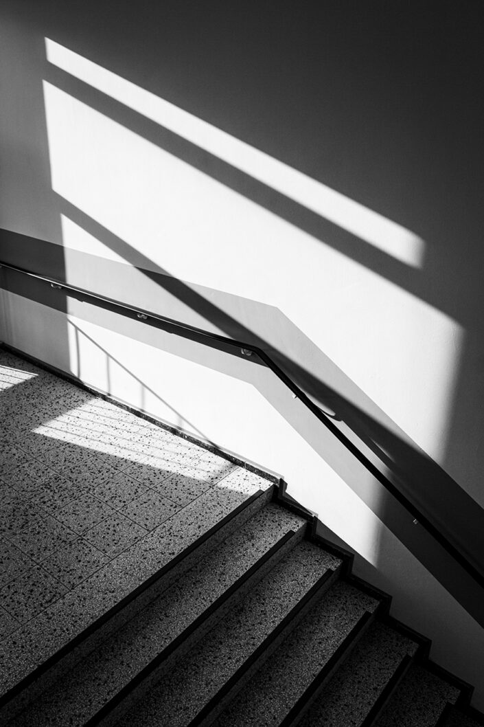 Geländer und einfallendes Licht an der Wand in einem Treppenhaus