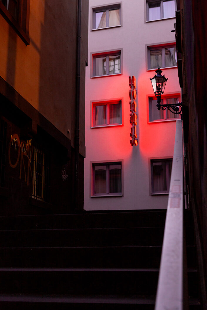 Leuchtreklame eines Hotels in einer Altstadtgasse