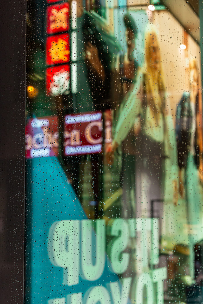 Spiegelungen und Regentropfen auf einem Schaufenster