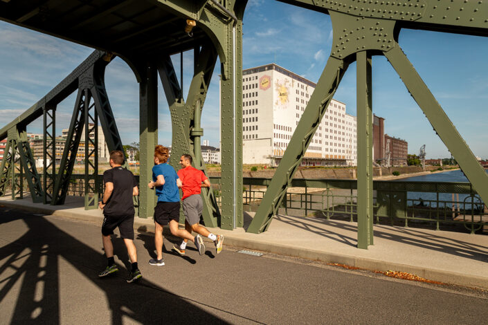 Drei Jogger auf der Drehbrücke in Deutz