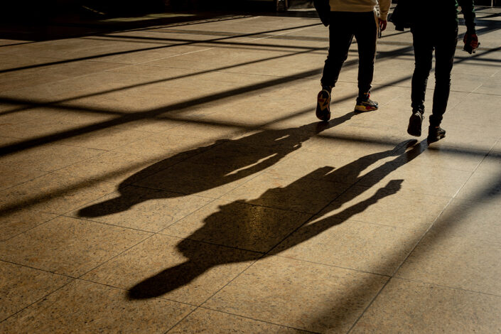 Schattenwurf von zwei Männern auf dem Boden der Eingangshalle des Hauptbahnhofs Köln