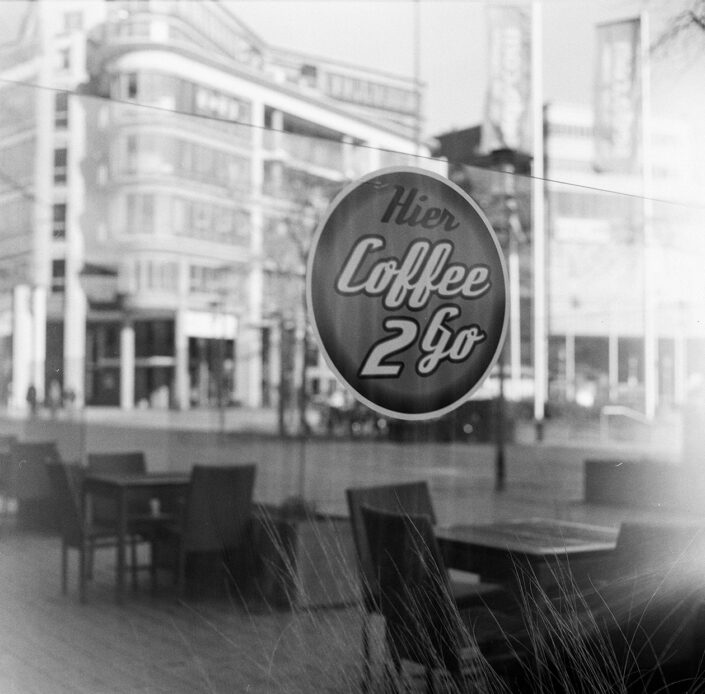 Aufkleber "Coffee to Go" an einem Café im Mediapark Köln, analog in Schwarz-Weiß fotografiert mit Kiew 88