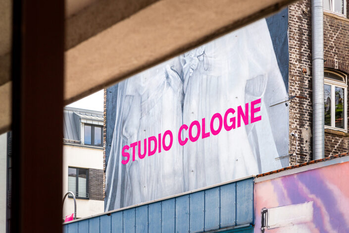 Werbebanner der Ausstellung Studio Cologne an einer Fassade in der Körnerstraße
