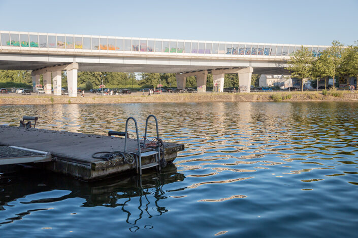 Plattform mit Pool-Leiter im Duisburger Innenhafen, im Hintergrund eine Autobahnbrücke