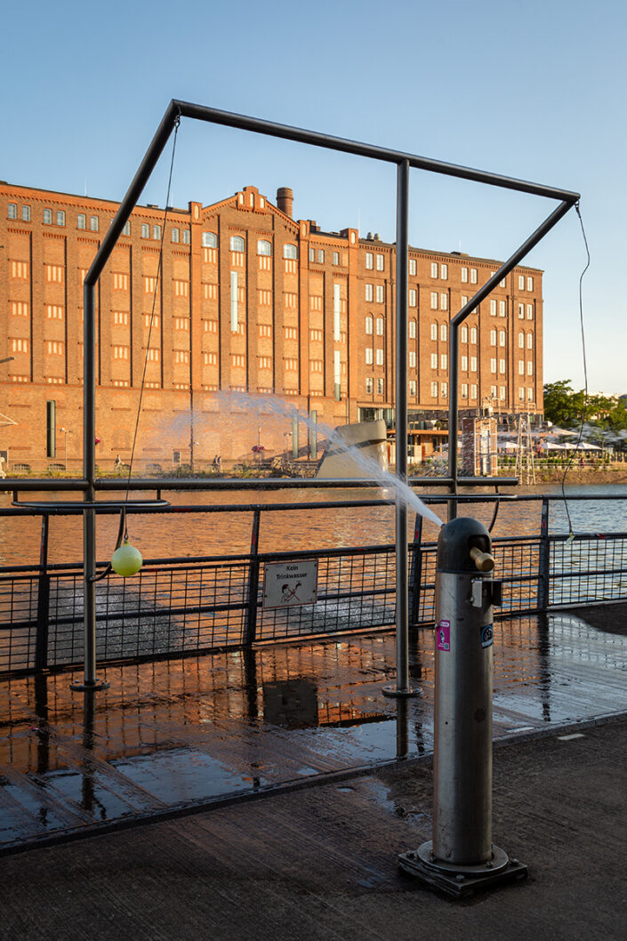 Gebäude im Duisburger Innenhafen. Im Vordergrund ein Wasserspiel