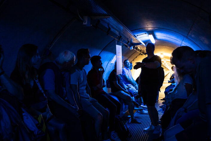 Besucher in der blau beleuchtete Mitte des Fernwärmetunnels der RheinEnergie Köln